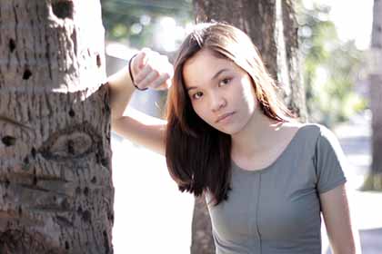 A Cebuana leaning against a tree